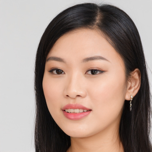 Joyful asian young-adult female with long  black hair and brown eyes