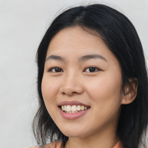 Joyful asian young-adult female with long  black hair and brown eyes