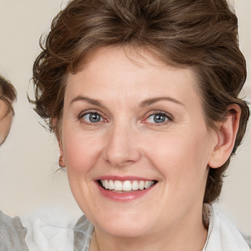 Joyful white young-adult female with medium  brown hair and blue eyes