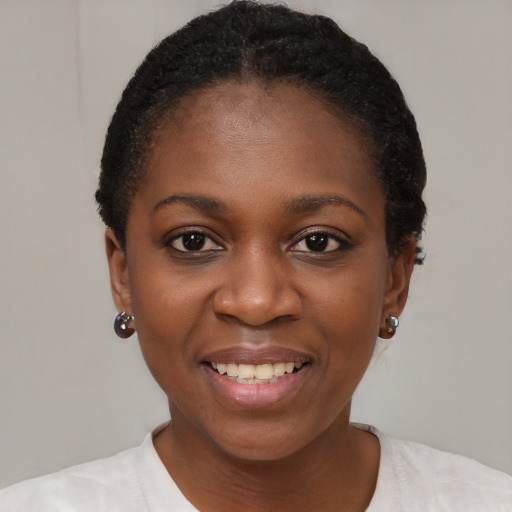 Joyful black young-adult female with short  black hair and brown eyes