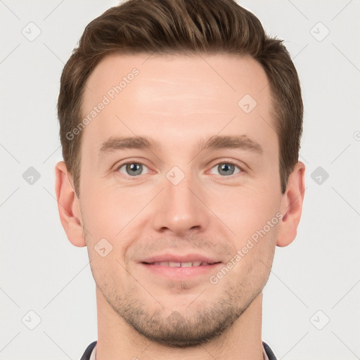 Joyful white young-adult male with short  brown hair and grey eyes