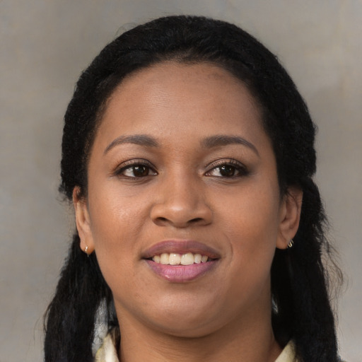 Joyful black young-adult female with long  black hair and brown eyes