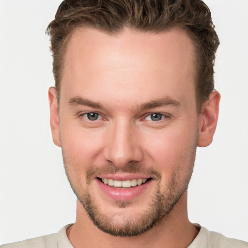 Joyful white young-adult male with short  brown hair and blue eyes