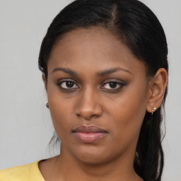 Joyful black young-adult female with long  brown hair and brown eyes