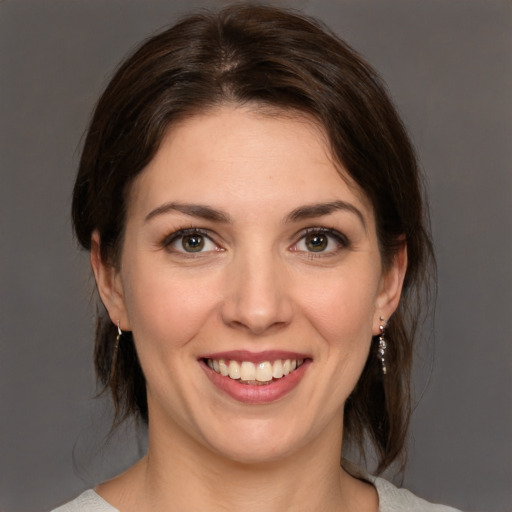 Joyful white young-adult female with medium  brown hair and green eyes