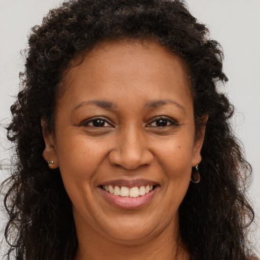 Joyful black adult female with long  brown hair and brown eyes