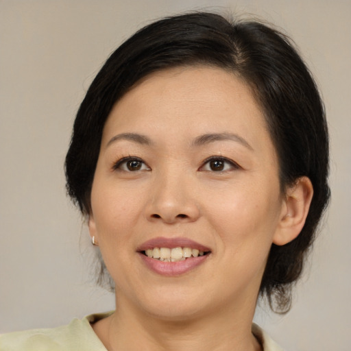 Joyful asian adult female with medium  brown hair and brown eyes
