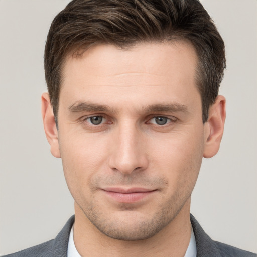 Joyful white young-adult male with short  brown hair and grey eyes