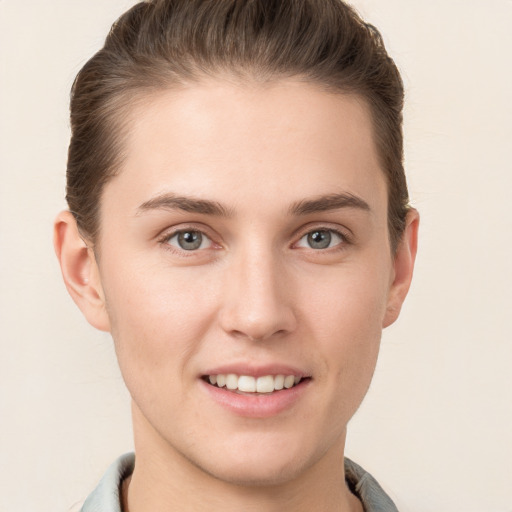 Joyful white young-adult female with short  brown hair and grey eyes