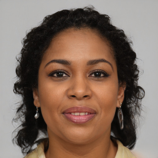 Joyful black young-adult female with long  brown hair and brown eyes