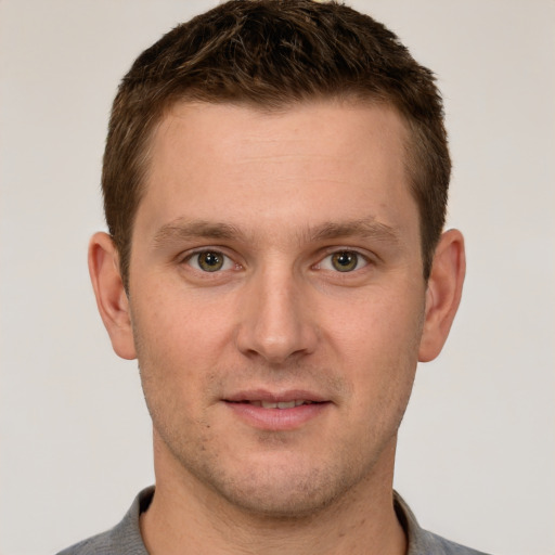 Joyful white young-adult male with short  brown hair and grey eyes