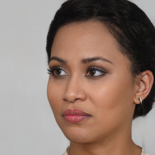 Joyful black young-adult female with medium  black hair and brown eyes