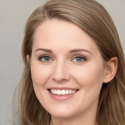 Joyful white young-adult female with long  brown hair and grey eyes