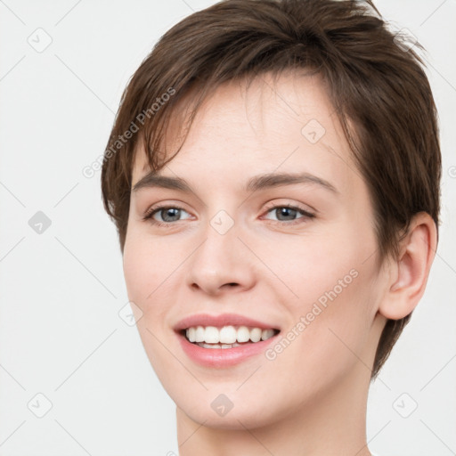 Joyful white young-adult female with short  brown hair and grey eyes