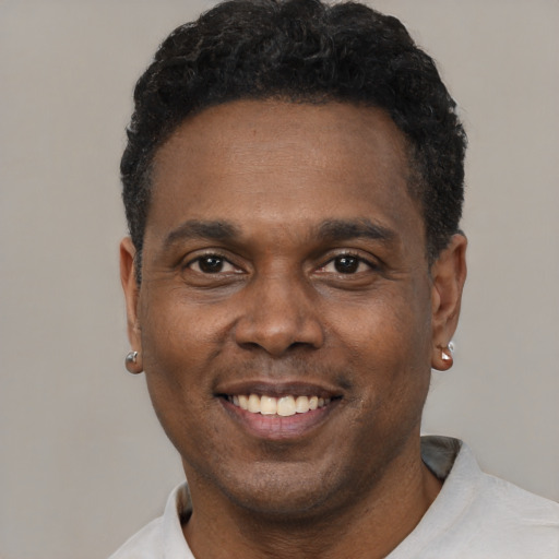 Joyful black young-adult male with short  black hair and brown eyes