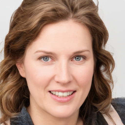 Joyful white young-adult female with long  brown hair and blue eyes