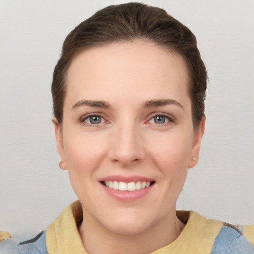 Joyful white young-adult female with short  brown hair and grey eyes