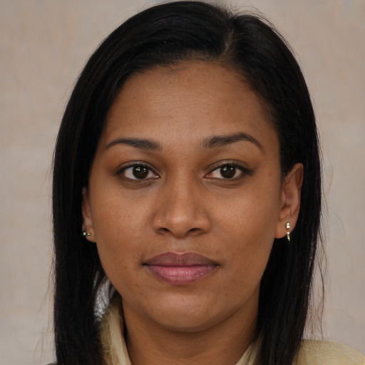 Joyful black young-adult female with long  brown hair and brown eyes