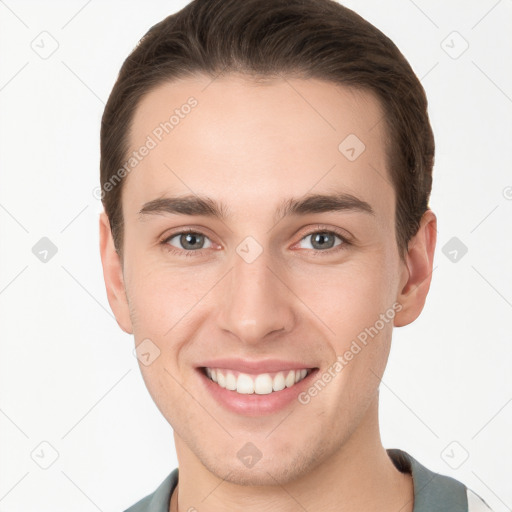 Joyful white young-adult male with short  brown hair and grey eyes