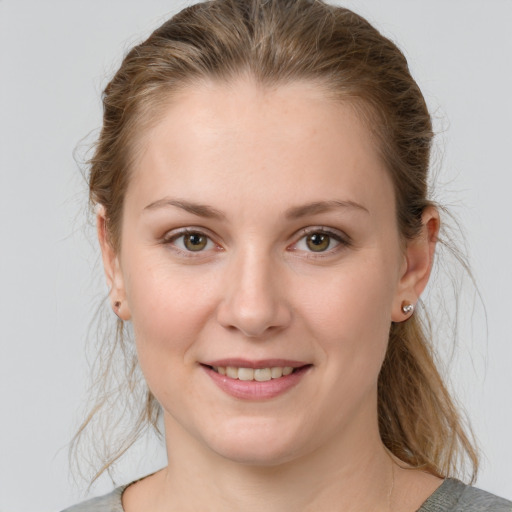 Joyful white young-adult female with medium  brown hair and grey eyes