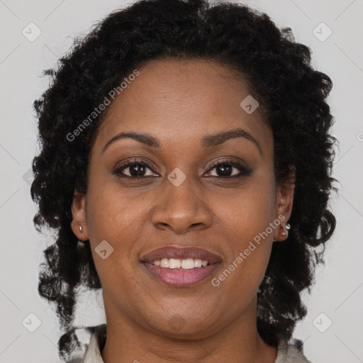 Joyful black adult female with long  brown hair and brown eyes
