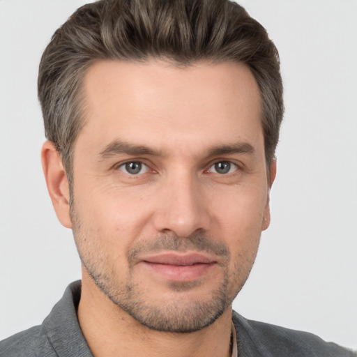 Joyful white adult male with short  brown hair and brown eyes