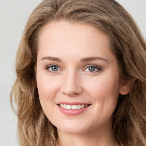 Joyful white young-adult female with long  brown hair and green eyes