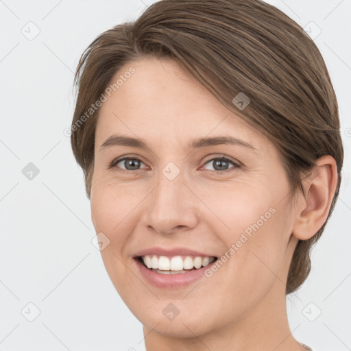 Joyful white young-adult female with medium  brown hair and grey eyes