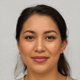 Joyful latino young-adult female with medium  brown hair and brown eyes