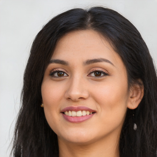 Joyful latino young-adult female with long  brown hair and brown eyes