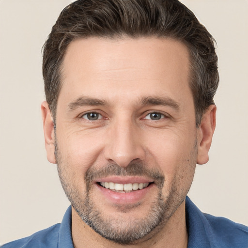 Joyful white adult male with short  brown hair and brown eyes