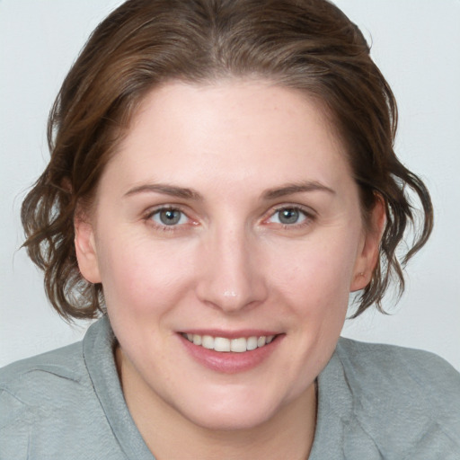 Joyful white young-adult female with medium  brown hair and blue eyes