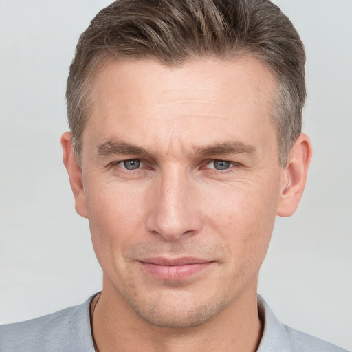 Joyful white adult male with short  brown hair and grey eyes