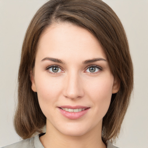 Joyful white young-adult female with medium  brown hair and green eyes