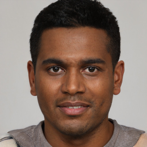 Joyful black young-adult male with short  black hair and brown eyes
