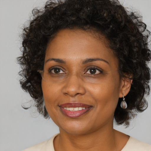 Joyful black adult female with medium  brown hair and brown eyes