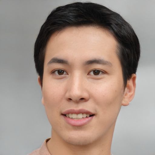 Joyful asian young-adult male with short  brown hair and brown eyes