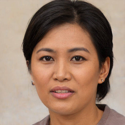 Joyful asian young-adult female with medium  brown hair and brown eyes
