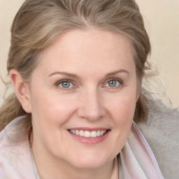 Joyful white adult female with medium  brown hair and blue eyes