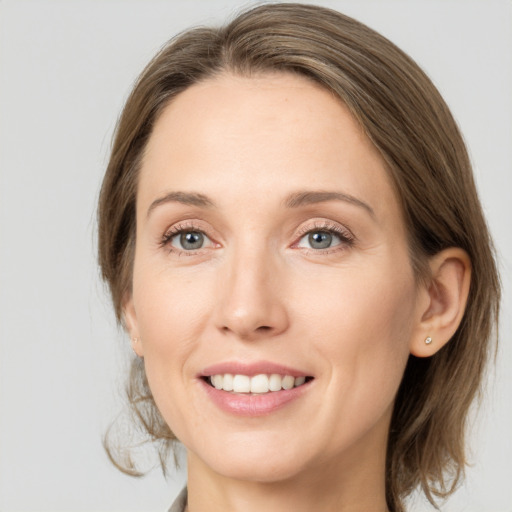 Joyful white young-adult female with medium  brown hair and grey eyes