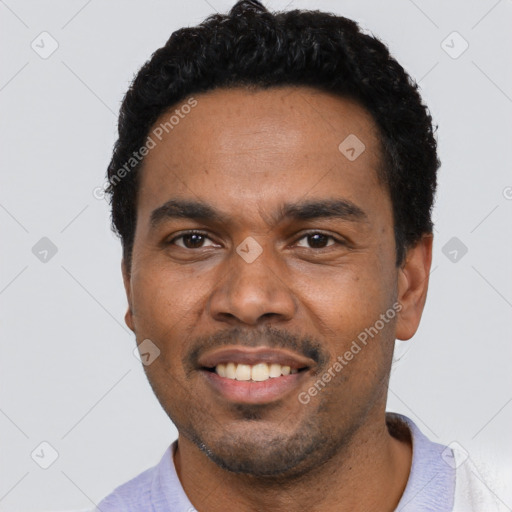 Joyful black young-adult male with short  black hair and brown eyes