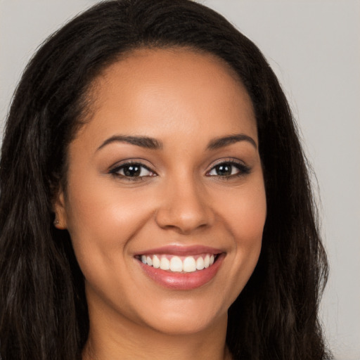 Joyful latino young-adult female with long  brown hair and brown eyes