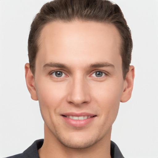 Joyful white young-adult male with short  brown hair and grey eyes