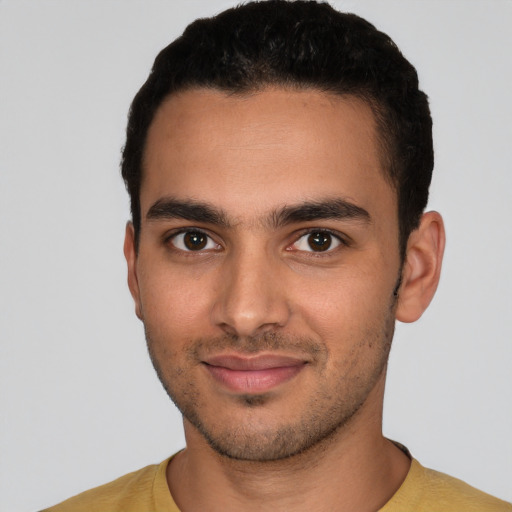 Joyful latino young-adult male with short  brown hair and brown eyes