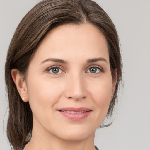 Joyful white young-adult female with medium  brown hair and grey eyes