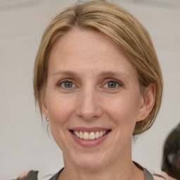 Joyful white adult female with medium  brown hair and blue eyes