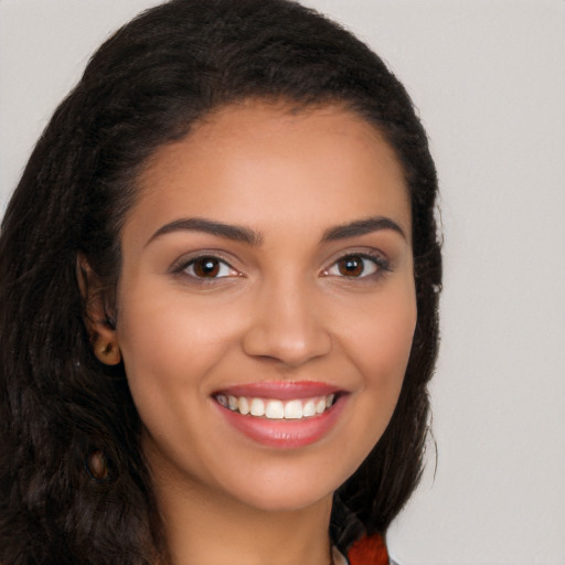 Joyful latino young-adult female with long  brown hair and brown eyes