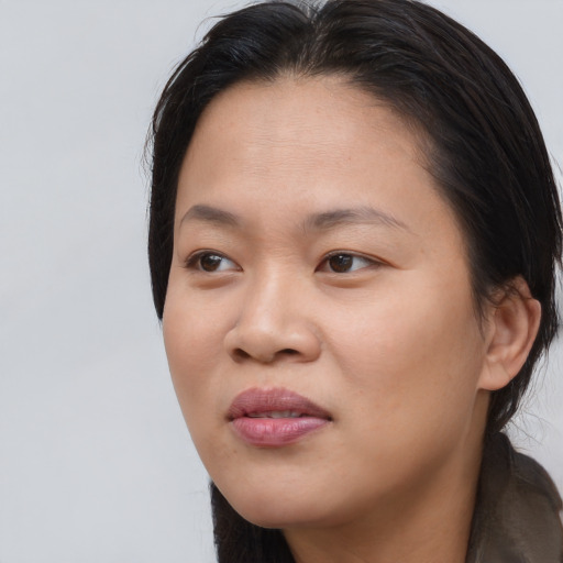 Joyful asian young-adult female with medium  brown hair and brown eyes