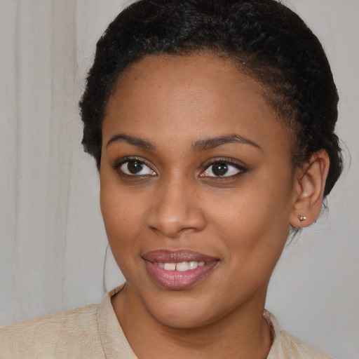 Joyful black young-adult female with short  brown hair and brown eyes