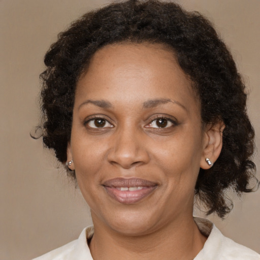 Joyful black adult female with medium  brown hair and brown eyes